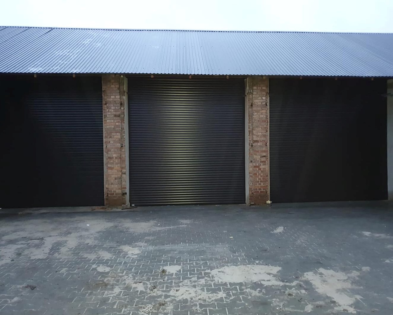 trzy ciemne bramy w budynku gosodarczym