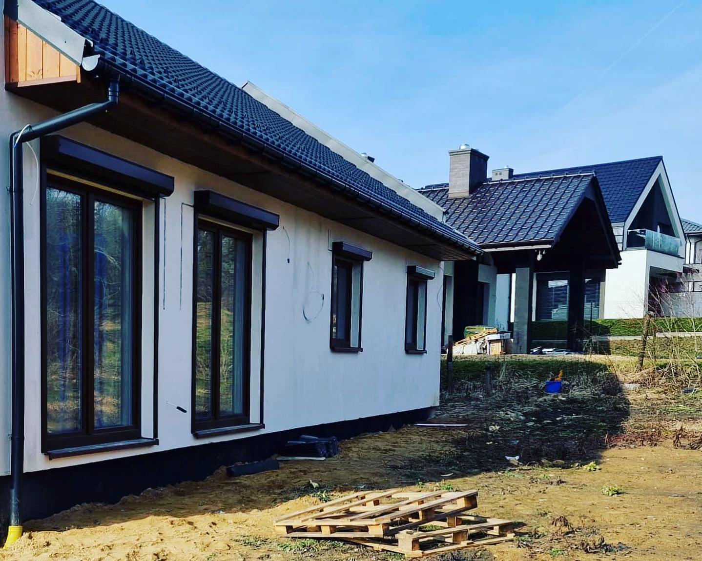 dwie rolety balkonowe i dwie okienne na jasnym domu