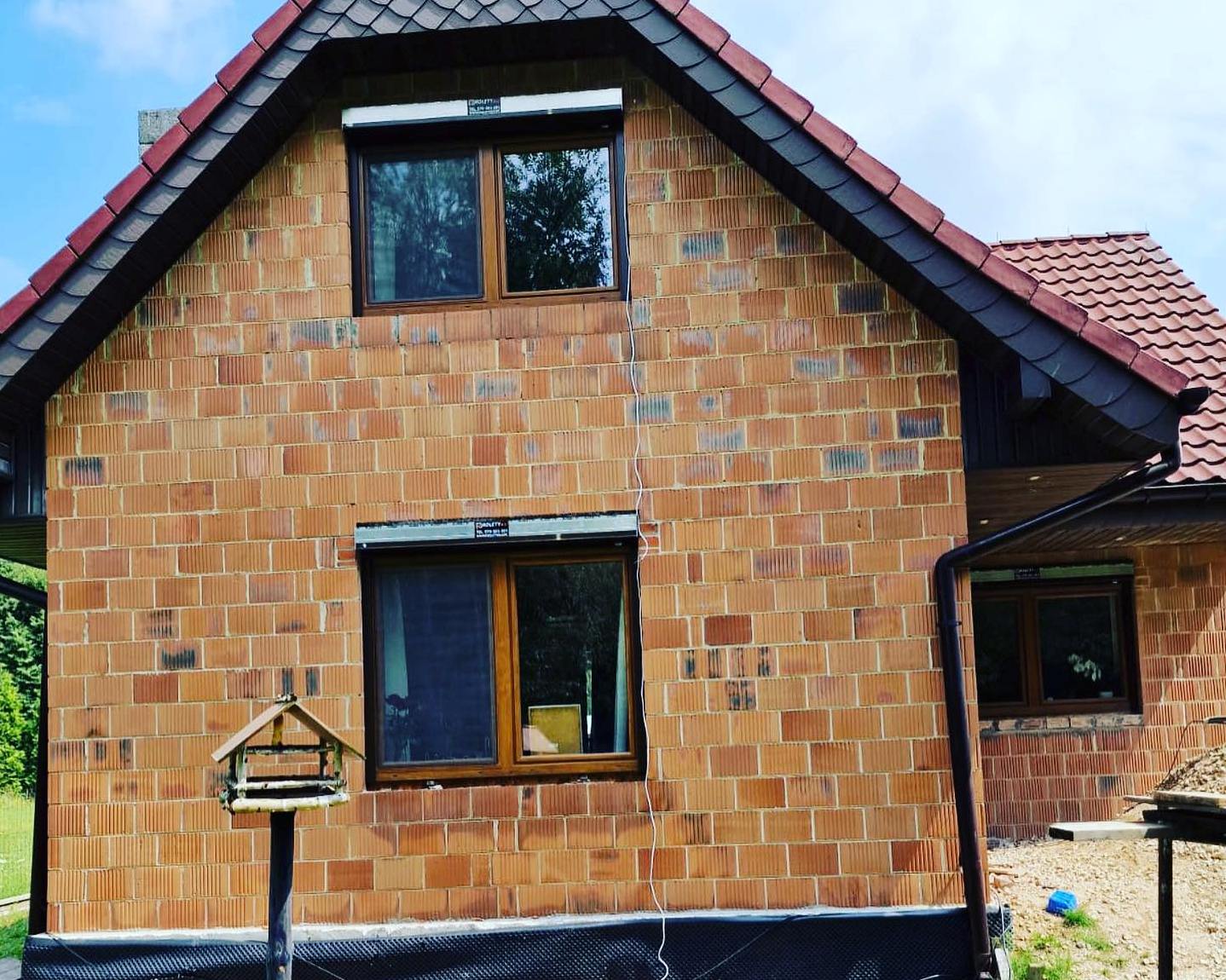 dwie rolety na nieotynkowanym domu