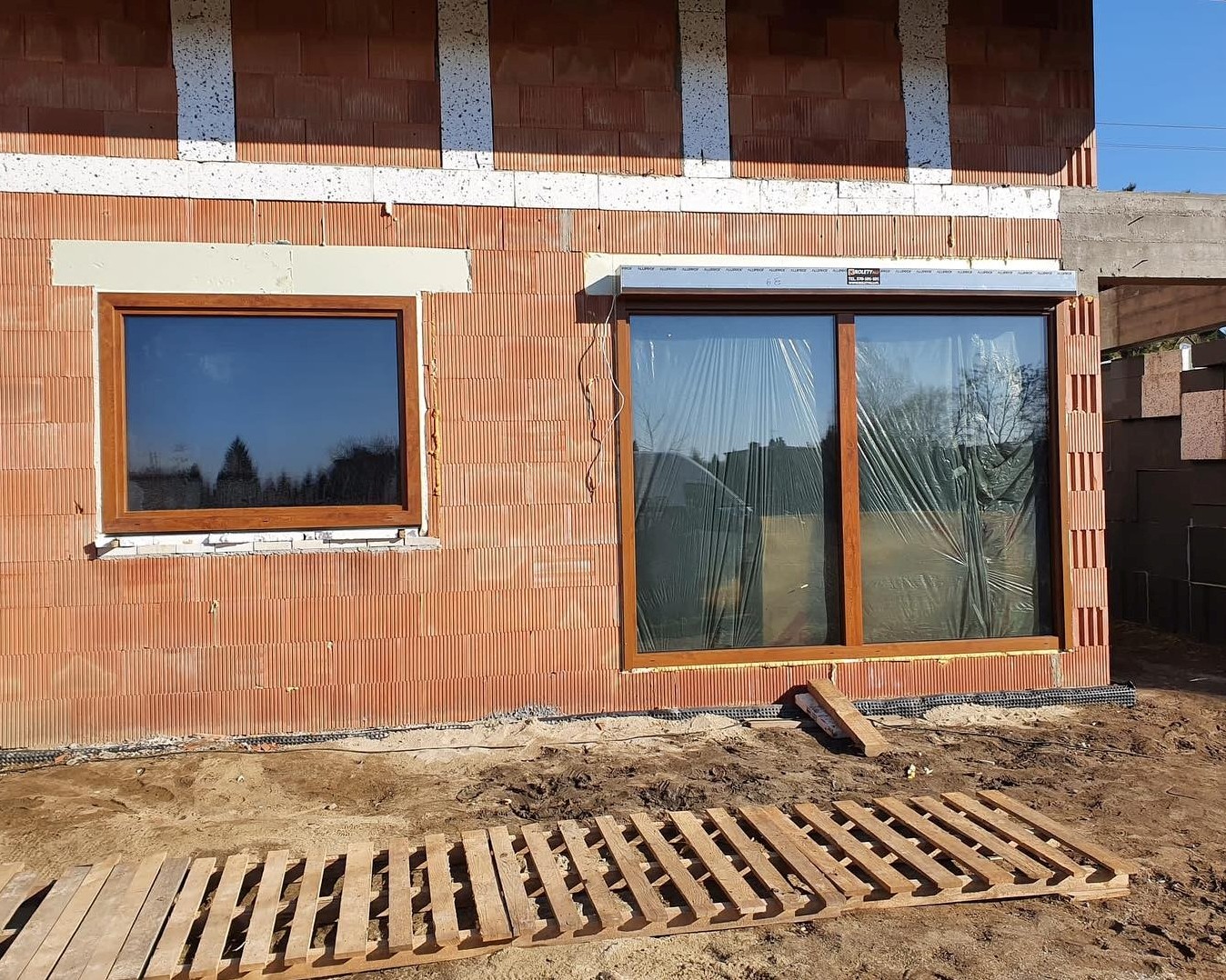 okno z roletą i odbijający się samochód