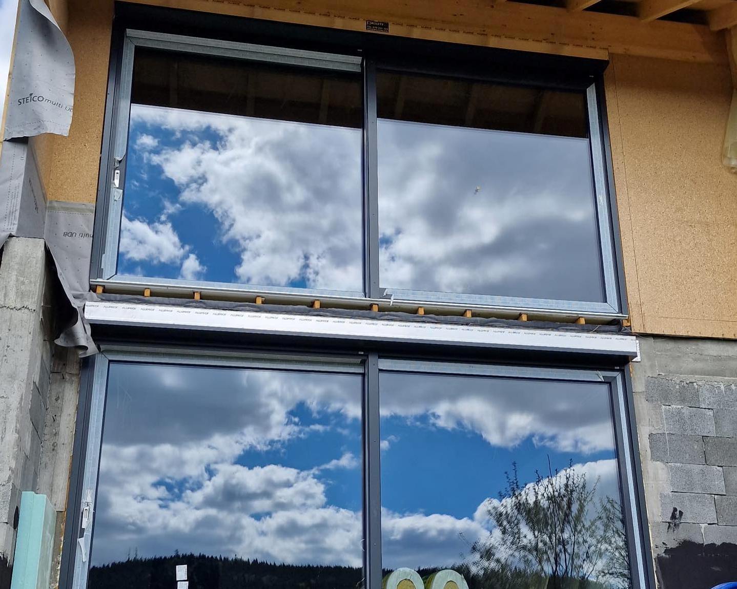 dwie rolety jedna nad drugą na dużych oknach